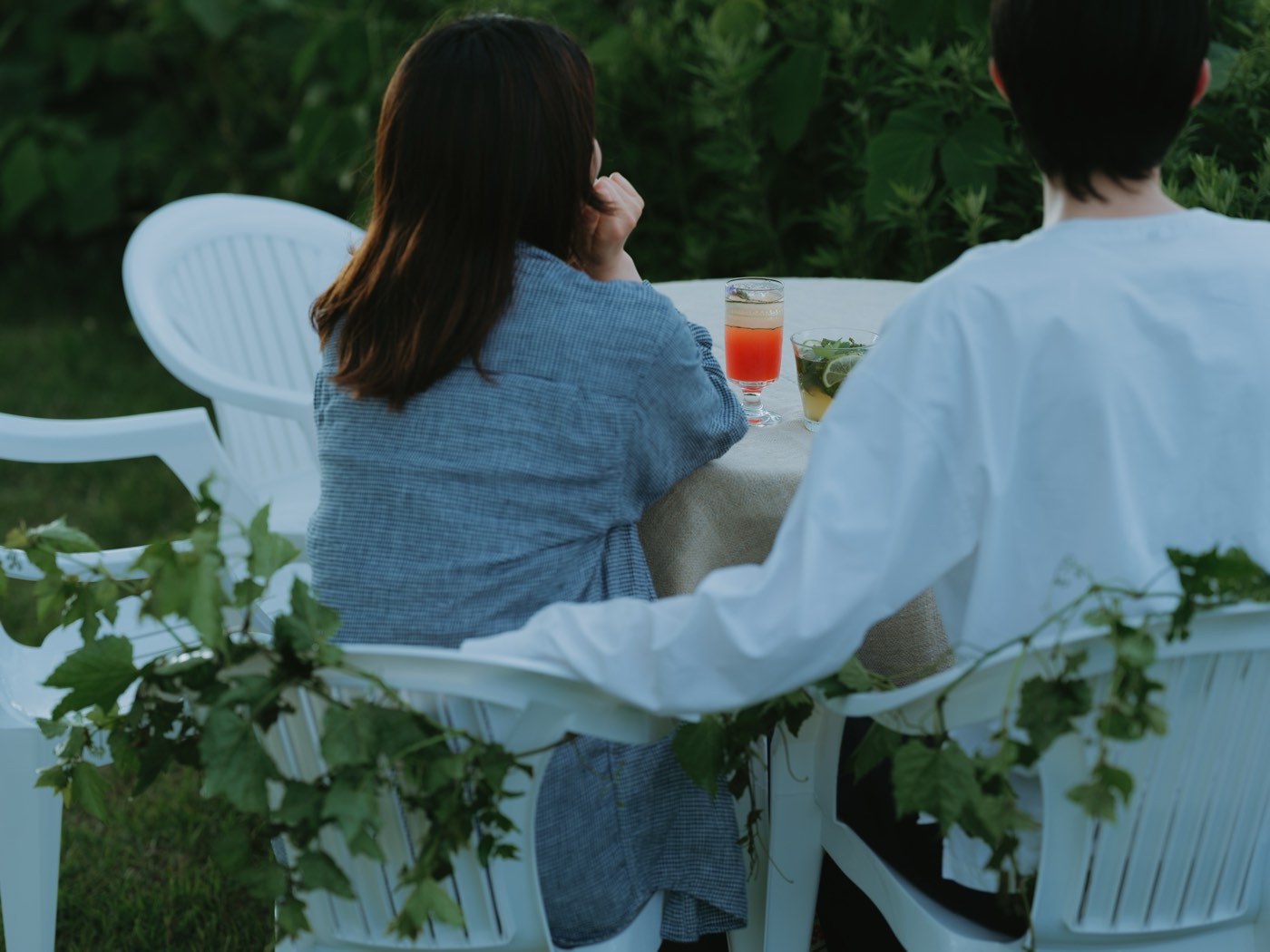 Two guests enjoying a welcome drink at a table at dusk